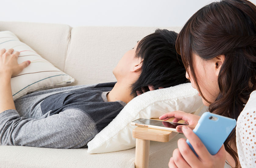 無断でパートナーののスマホを操作する女性