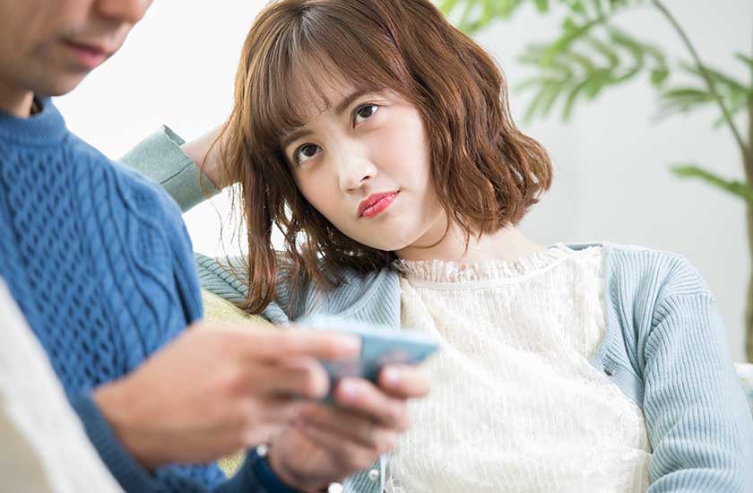 スマホばかり見ているパートナーの浮気を疑う女性