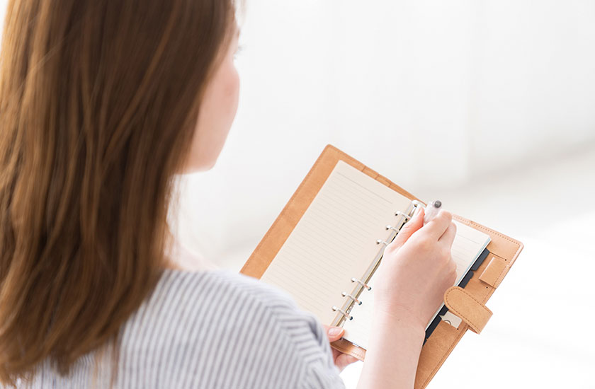 パートナーのスマホの使用状況をメモする女性