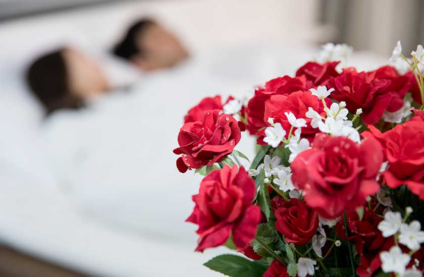 薔薇とベットで一緒に寝る男女