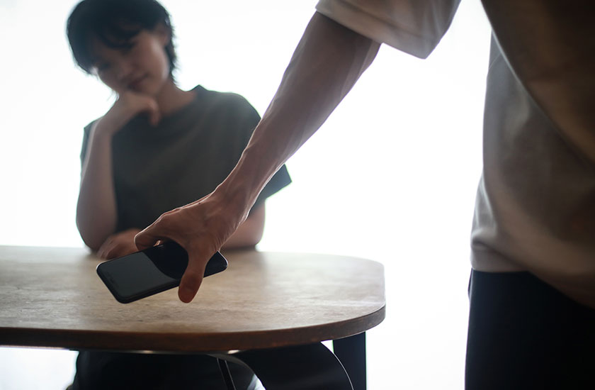 浮気相手とスマホで連絡をとる男性