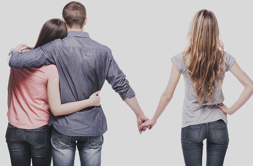 パートナーと抱き合いながら、他の女性と手を繋ぐ男性