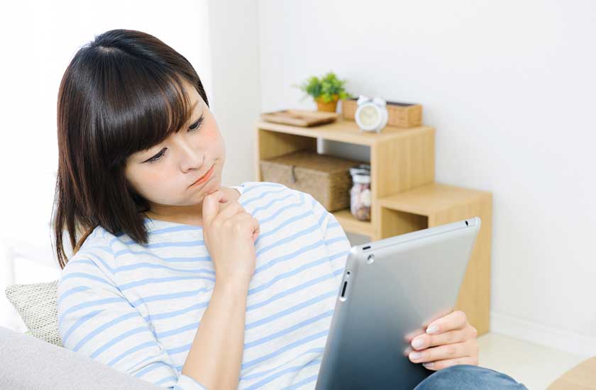 ネットで探偵事務所を探す女性