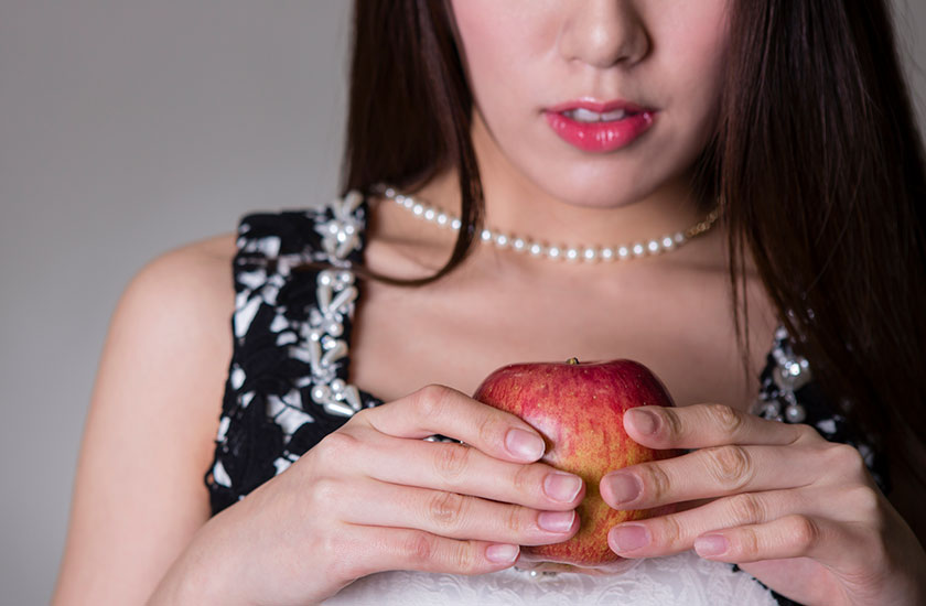 リンゴを両手に持つ女性