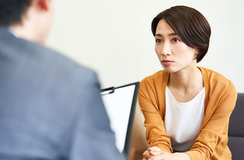 探偵事務所で調査プランの説明を受ける依頼者
