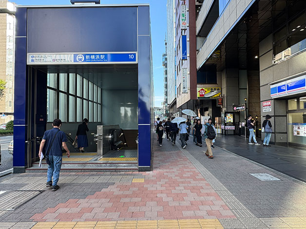 「10番出口」を地上に出たら、すぐUターンしてJR横浜駅方向（日産スタジアムから離れる方向）に進みます。