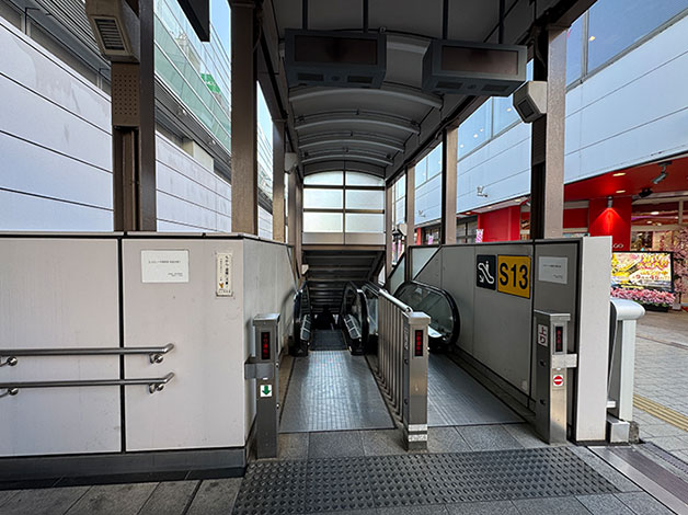 パチコン店「PREGO」の手前・左側にあるエスカレーターで地上に降ります。